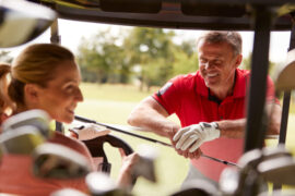 Couple Playing Golf,Driving Buggy And Talking Over Clubs