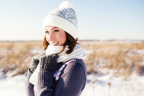 A woman in smiling in front of a snowy background