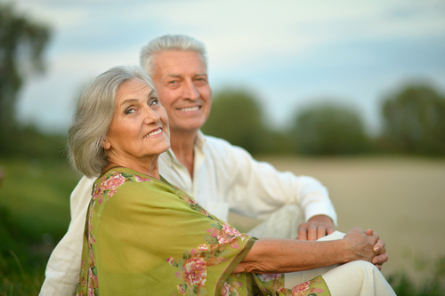Elderly couple sitting outside smiling