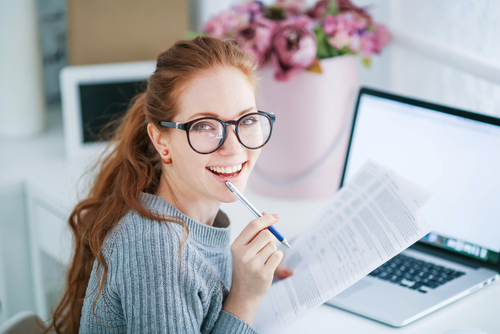 Young woman with glasses researching LASIK