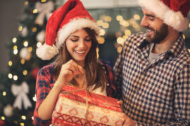 Festive holiday couple opening a Christmas gift